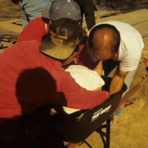 Archaeologists Nicholas Luccketti and William Leigh remove the plaster-encased cabasset helmet from Pit 1.