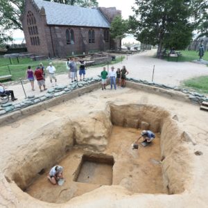 Visitors watching students excavating