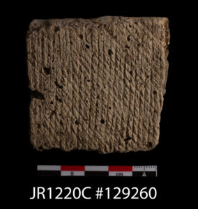 A shell tempered rim sherd of Native ceramic. This sherd is cord-marked in a "Z" pattern on its exterior. This sherd was found in a pit just inside James Fort's western palisade wall.