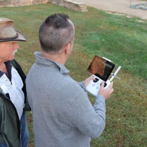 Two men use hand-held drone controller