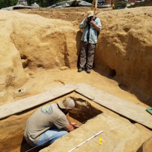 Photographer taking pictures of an archaeologist excavating