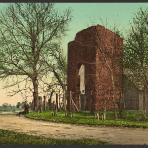 Postcard showing brick church tower and wooden barn