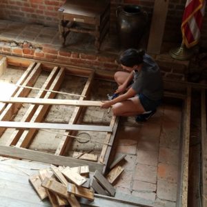 Student removing wooden platform with a hammer
