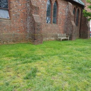 Grass area on the side of a brick church