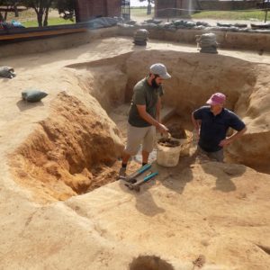 Archaeologists working in an excavation unit