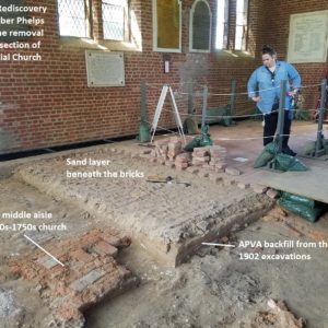 Staff examines excavated floor in brick church