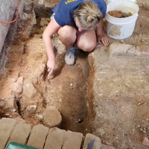 Archaeologist excavates brick foundations