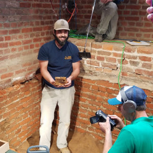 Archaeologist holding excavated metal box