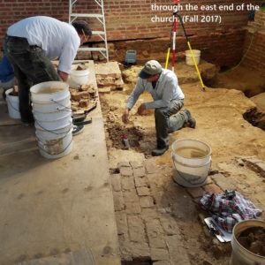 Archaeologists excavate brick and dirt church floor