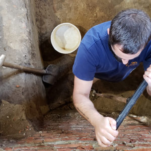 Archaeologist tests brick wall with an auger