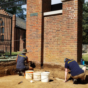 Archaeologists excavate in front of the brick entrance gate