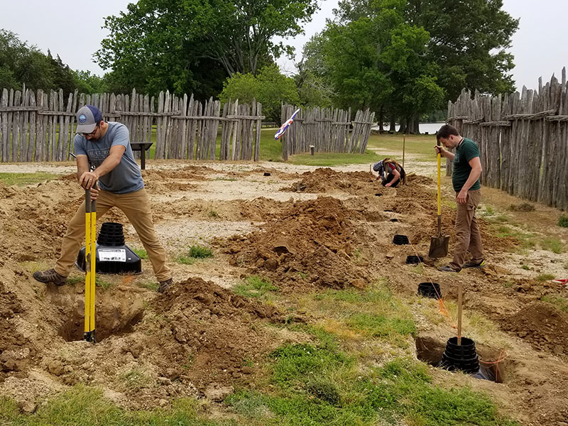 three men digging post holes