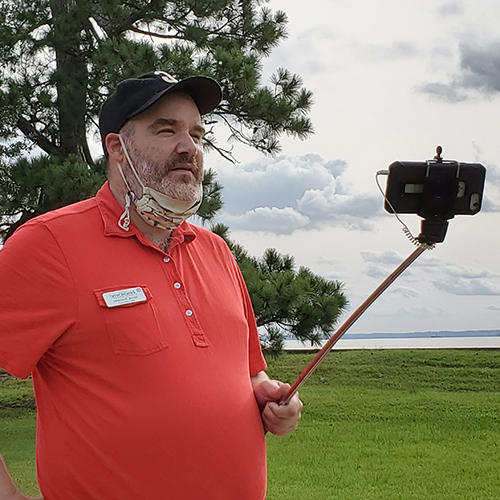 a Jamestown Rediscovery staff member uses a selfie stick to give a virtual tour