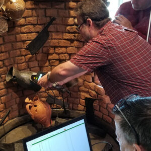 The conservation team takes pXRF readings from the pewter measure found in the Smithfield Well. (Back to front: Senior Conservator Dan Gamble, Senior Conservator Dr. Chris Wilkins, Conservator Don Warmke)