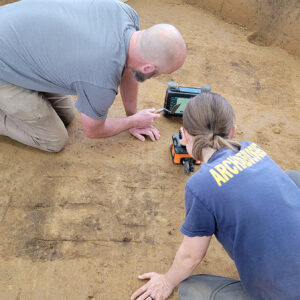 GSSI's Peter Leach and Staff Archaeologist Natalie Reid use ground-penetrating radar to "see" the burial below the surface. Note the stick figure etching on the grave approximating the location of the individual.