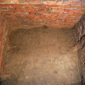Excavated floor by brick church walls
