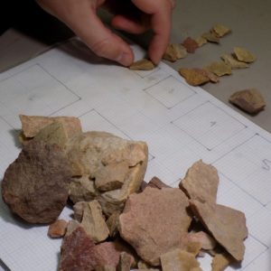 Lithic artifacts being measured on a size chart