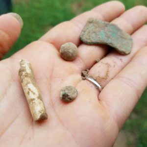 Hand holding assortment of small artifacts