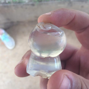 Hand holding glass bottle fragment