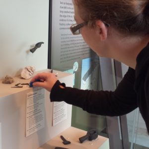 Conservator cleaning an artifact exhibit
