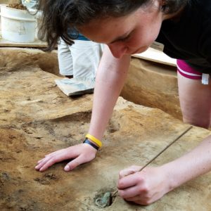 Excavator picks at artifacts in situ