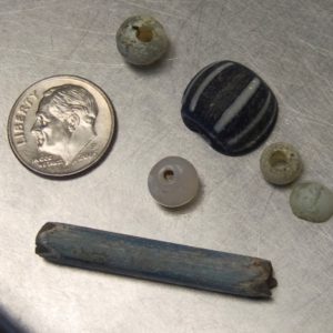 Round and elongated beads next to a dime for scale