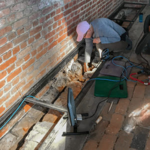 Excavator cleans exposed brick foundations