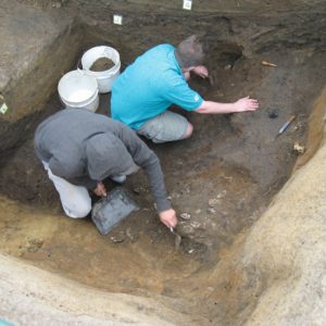 Archaeologists trowel in an excavation unit