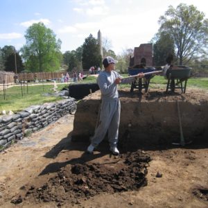 Archaeologist shoveling dirt into a wheelbarrow