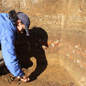 Archaeologist troweling in an excavation unit