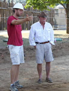 Archaeologist gesturing while talking with a colleague in an excavation area