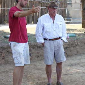 Archaeologist gesturing while talking with a colleague in an excavation area