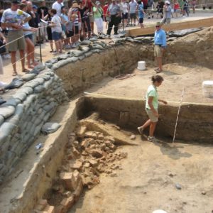 Group watches archaeologists examine cellar