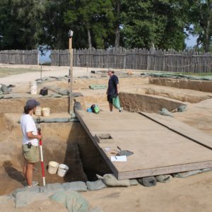 Archaeologists standing in an excavation unit