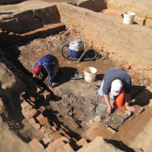 Archaeologists excavating brick-lined cellar