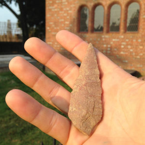 hand holding a quartzite projectile point