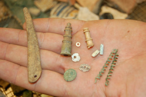 Hand holding an assortment of small artifacts