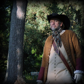 man in historical clothing in front of a forest