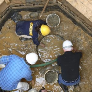 Archaeologists excavating a well