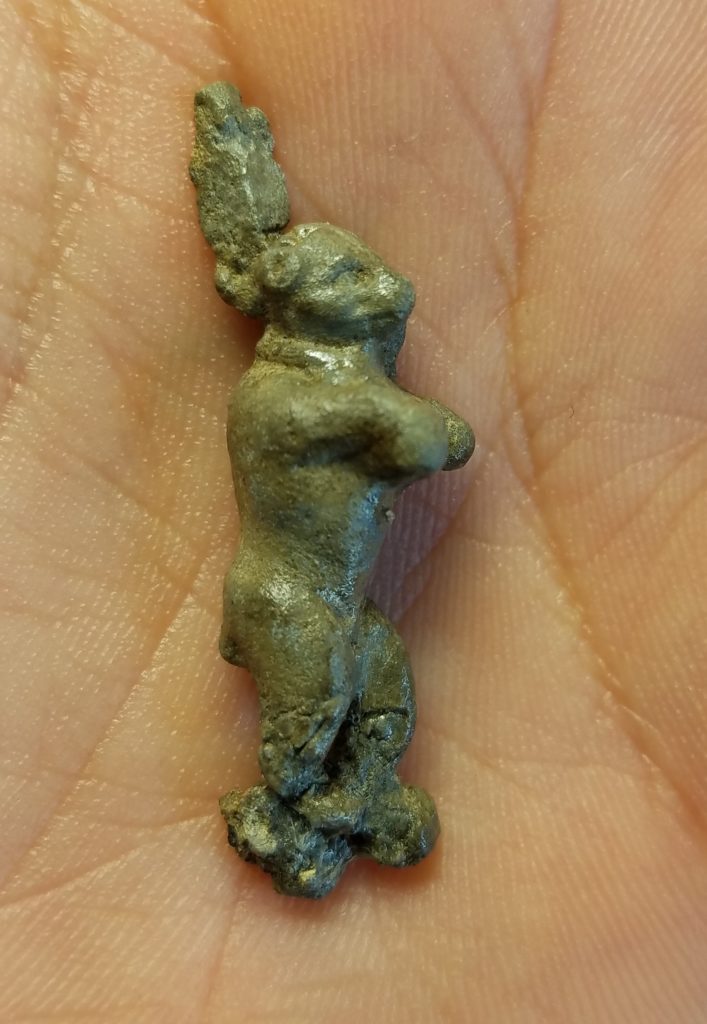 hand holding cast lead figurine in the shape of a standing bear