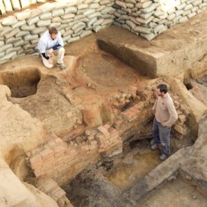 Archaeologists standing in excavation unit
