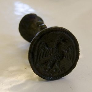 Side view of a brass seal with a falcon design