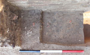 excavated trench beside a brick tower