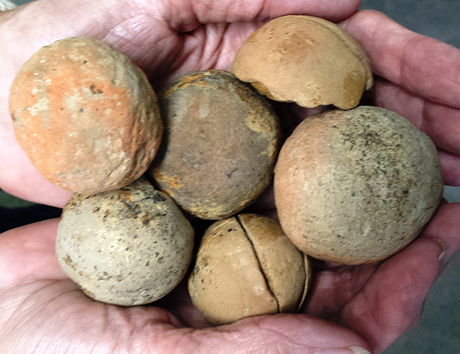 Hands holding clay balls of varying sizes
