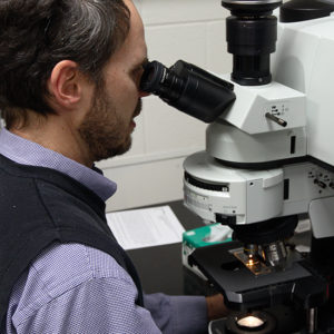 man looking through a microscope