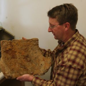 Conservator holding a corroded backplate