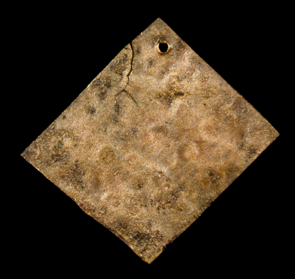 square cut copper piece with a pierced hole in one corner