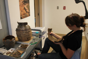 Curator mending an earthenware jar