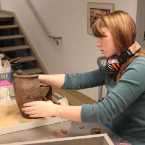 Curator mending an earthenware pot