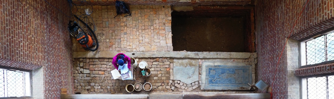Aerial view of archaeologist documenting excavations in brick church